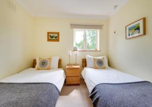 two twin beds in a room with a window at Meadow View in Middleton