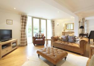 a living room with a couch and a television at Meadow Lodge in Ufford