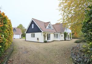 a row of white houses with red roofs at Meadow Lodge in Ufford