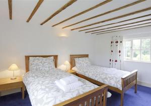 a bedroom with two beds and two windows at Kings Farm in Wangford