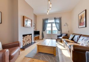 Meadow House في Blythburgh: غرفة معيشة مع أريكة ومدفأة