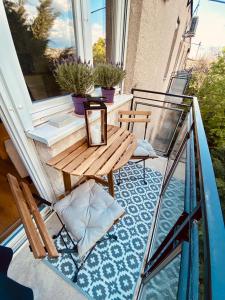 een balkon met een houten tafel en een glazen leuning bij Mrs. Columbo's Flat in Boedapest