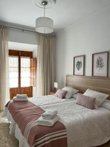 a bedroom with a large bed with towels on it at Apartamento Camberos Antequera in Antequera