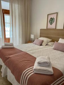 安特克拉的住宿－Apartamento Camberos Antequera，一间卧室配有两张带毛巾的床