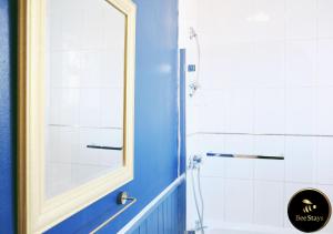 La salle de bains est pourvue d'un miroir et d'une douche. dans l'établissement Bee Stays - Cooper House, à Haydock