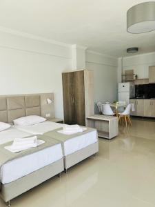 a large bedroom with two beds and a kitchen at Colibri in Kallithea Halkidikis