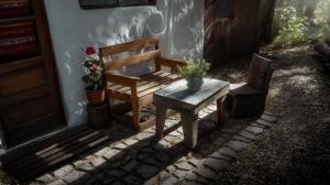 un banco de madera y una mesa con flores junto a una puerta en Casa en Bariloche en San Carlos de Bariloche