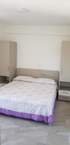 ein Schlafzimmer mit einem großen Bett mit violetter Bettwäsche in der Unterkunft Fattoria Moresco in Peschici