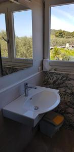 ein weißes Waschbecken im Badezimmer mit zwei Fenstern in der Unterkunft Fattoria Moresco in Peschici