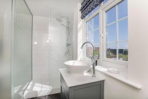 a white bathroom with a sink and a shower at Holtby Grange Cottages in York +55 photos