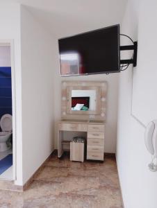 a flat screen tv on a wall in a room at Hospedaje Rey De Los Vientos in Yotoco