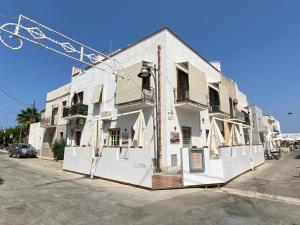 a white building with a crane on the side of it at Ca Sà Bellò San Vito Lo Capo in San Vito lo Capo