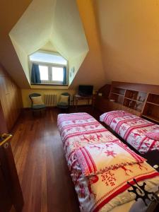 an attic room with two beds and a window at Bed & Breakfast Chez Berry in Aosta