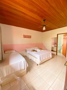 a bedroom with two beds and a wooden ceiling at Topo do Cipó Ecopousada Vegana in Serra do Cipo