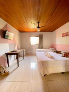 a bedroom with two beds and a wooden ceiling at Topo do Cipó Ecopousada Vegana in Serra do Cipo