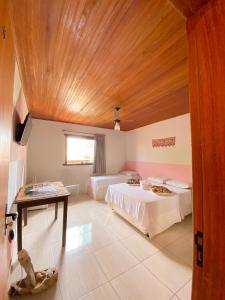 a bedroom with two beds and a wooden ceiling at Topo do Cipó Ecopousada Vegana in Serra do Cipo