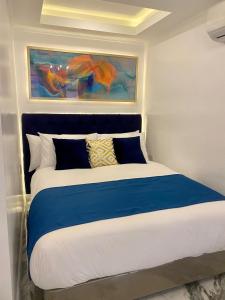 a bedroom with a large bed with blue and white sheets at MAKATI Isabela Luxury in Manila