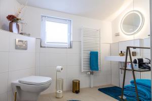 a white bathroom with a toilet and a window at nidusROOMS: Art Déco Apartment nähe Heidelberg in Leimen