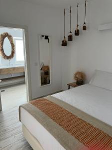 um quarto branco com uma cama e um espelho em À Espera - Turismo Rural,Melides em Melides