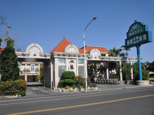 a building with a sign in front of a street at Travel Road Motel in Hualien City