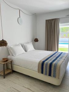 ein weißes Schlafzimmer mit einem großen Bett und einem Fenster in der Unterkunft À Espera - Turismo Rural,Melides in Melides
