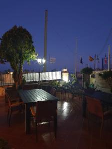 eine Gruppe von Tischen und Stühlen auf einer Terrasse in der Nacht in der Unterkunft Hotel Mareluna Ischia in Ischia