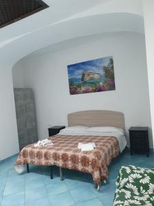 a bedroom with a bed and a painting on the wall at Hotel Mareluna Ischia in Ischia