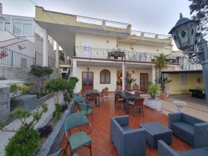 a patio with chairs and tables and a building at Hotel Mareluna Ischia in Forio d'Ischia