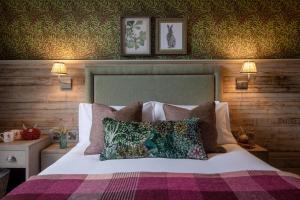 sypialnia z łóżkiem z poduszkami w obiekcie The Red Lion & Manor House w mieście Burnsall