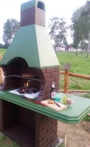 un horno de ladrillo con una mesa con comida y una botella en Domki nad Soliną, en Olchowiec