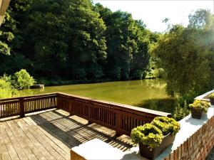 a wooden bridge over a river with trees in the background at Salaš Mlýn in Velehrad