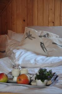 OlchowiecにあるDomki nad Solinąのりんごとカップが入ったベッドの上に食料品を入れたトレイ