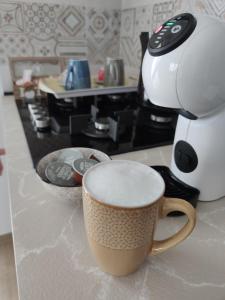 una taza de café sentada en un mostrador junto a una cafetera en B&B Stella Di Mare - Ortona en Ortona