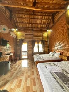 a large room with two beds and a wooden ceiling at Sunny Eco Lodge in Cat Tien