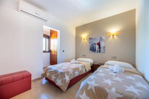 a bedroom with two beds and a red chair at Villa Cas Pla 33 in Sant Joan de Labritja