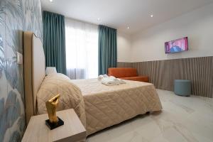 una camera d'albergo con letto e sedia di P.C. Boutique H. LifeStyle, Napoli Centro, by ClaPa Group Dislocated Hospitality a Napoli