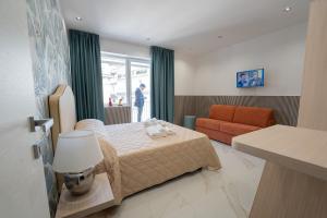Habitación de hotel con cama y sofá en P.C. Boutique H. LifeStyle, Napoli Centro, by ClaPa Group Dislocated Hospitality, en Nápoles