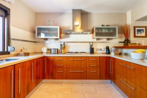 een keuken met houten kasten en een wastafel bij Villa Cas Pla 33 in Sant Joan de Labritja
