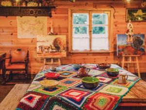 een tafel in een kamer met een tafelkleed erop bij Countryside cottage in Be czna with roofed terrace 