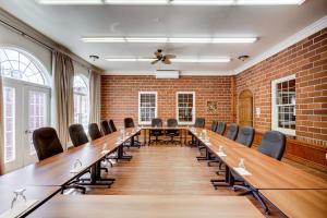 una gran sala de conferencias con una mesa larga y sillas en Le Grand Hôtel, en Baie-Comeau