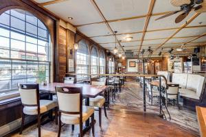 a dining room with tables and chairs and windows at Le Grand Hôtel in Baie-Comeau