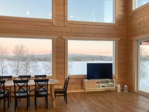 a dining room with a table and chairs and windows at Holiday Home Villa lehtoniemi by Interhome in Sonka