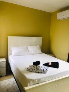 a bedroom with a white bed with towels on it at J&W apartment in San Felipe de Puerto Plata