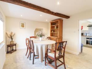 eine Küche und ein Esszimmer mit einem Tisch und Stühlen in der Unterkunft Tolldish Cottage in Stafford