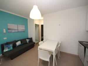 Apartment Veranda by Interhome في روزابينيتا: غرفة معيشة مع أريكة سوداء وطاولة بيضاء