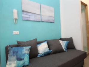 Apartment Veranda by Interhome في روزابينيتا: أريكة مع وسائد في غرفة المعيشة