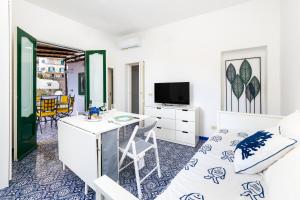 a room with a bed and a desk and a tv at Positano Dream Home in Positano