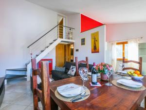 a dining room with a wooden table and a room with a staircase at Apartment Angela by Interhome in Rosignano Solvay