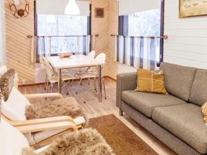 ein Wohnzimmer mit Sofa und Tisch in der Unterkunft Holiday Home Mustalampi 3 lintukoto by Interhome in Niskala