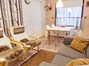 ein Wohnzimmer mit einem Tisch, Stühlen und einem Sofa in der Unterkunft Holiday Home Mustalampi 3 lintukoto by Interhome in Niskala
